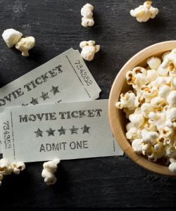 Close up of popcorn in bowl and two movie tickets